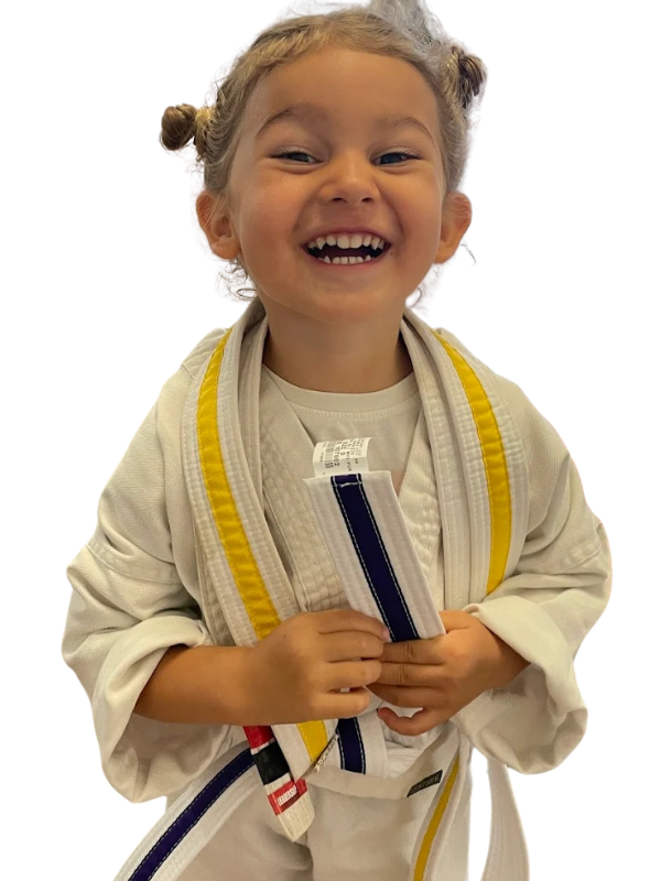 Smiling young Little Dragons student in a white gi holding a yellow-striped belt